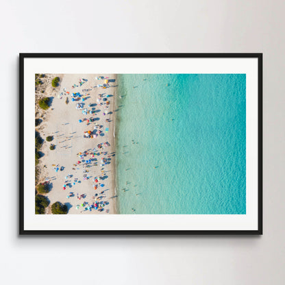 View from above, stunning aerial view of a white sand beach full of beach umbrellas and people swimming in a turquoise water. Spiaggia del Principe, Costa Smeralda, Sardinia, Italy.