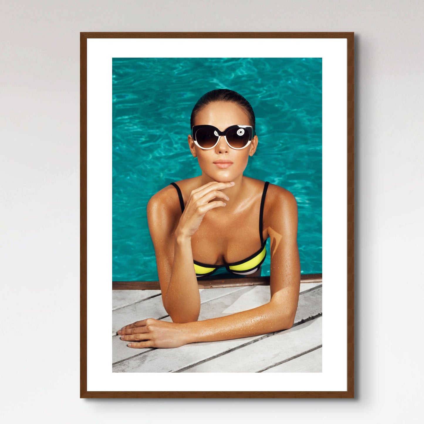 woman near the pool, wearing glasses and swimsuit, tans