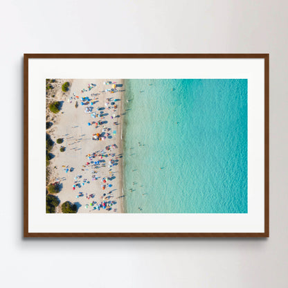 View from above, stunning aerial view of a white sand beach full of beach umbrellas and people swimming in a turquoise water. Spiaggia del Principe, Costa Smeralda, Sardinia, Italy.