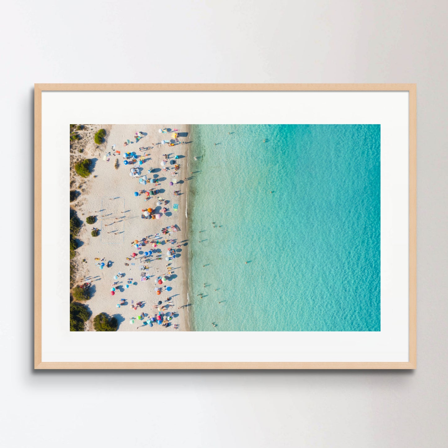 View from above, stunning aerial view of a white sand beach full of beach umbrellas and people swimming in a turquoise water. Spiaggia del Principe, Costa Smeralda, Sardinia, Italy.