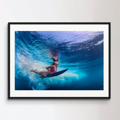 Beautiful surfer girl diving under water with surf board