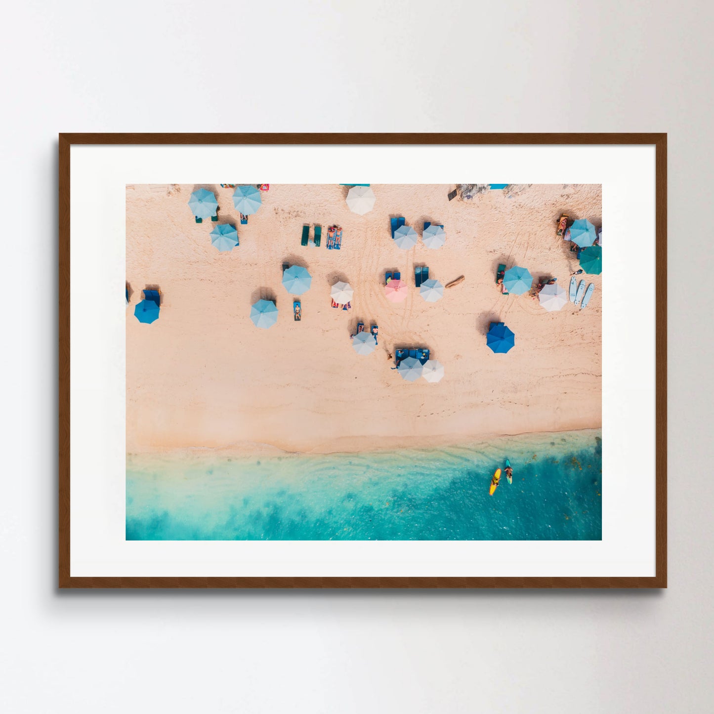 Top view of sandy beach with turquoise sea water and colorful blue umbrellas, aerial drone shot