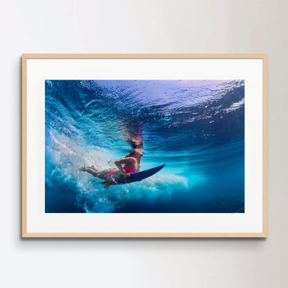 Beautiful surfer girl diving under water with surf board